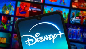 Disney plus logo on phone, app homepage in background