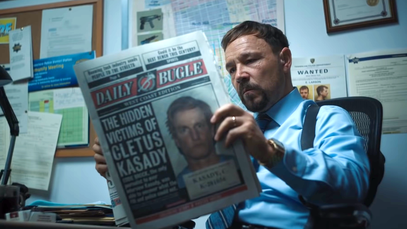 A police officer reading a copy of the Daily Bugle